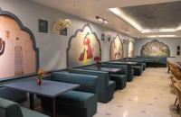 un restaurante con mesas, sillas y pinturas en las paredes en Hotel Melrose Inn, en Aligarh