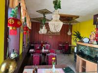 ein Restaurant mit Tischen und Stühlen und einem Kronleuchter in der Unterkunft Ferienwohnung Goldener Drache in Adorf