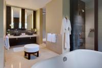 a bathroom with a tub and a toilet and a sink at Capella Singapore in Singapore