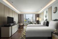 ein Hotelzimmer mit zwei Betten und einem Fernseher in der Unterkunft Siam Kempinski Hotel Bangkok in Bangkok