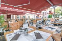 an outdoor restaurant with tables and chairs and umbrellas at Duplex (5pers) dans village vacances en Ardèche in Grospierres