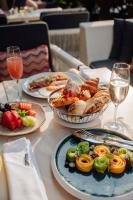 ein Tisch mit Tellern mit Essen und Gläsern Wein in der Unterkunft Siam Kempinski Hotel Bangkok in Bangkok