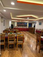 Hotel KASTURI PALACE & RESTAURANT DARJEELING في دارجيلنغ: غرفة طعام مع طاولات وكراسي خشبية