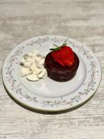 Un postre de chocolate con una fresa en un plato. en Entre Midi - Maison d'Hôtes - B&B, en Capestang