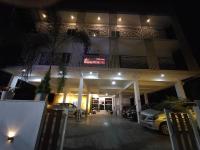 een hotel met 's nachts buiten geparkeerde auto's bij The Mountmist Apartment in Cochin