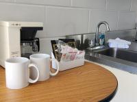 zwei Kaffeetassen auf einer Theke neben einem Waschbecken in der Unterkunft Beachcomber Motel in Ocean City