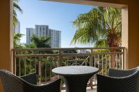 a table and chairs on a balcony with a palm tree at The Ritz-Carlton, Sarasota in Sarasota