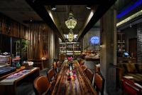 a dining room with a long wooden table and chairs at Huangshan Shanshuijian Wei Boutique Hotel in Huangshan