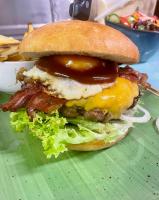 Un sándwich con tocino y queso en un plato verde. en Ludwigs, en Edenkoben