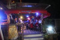 um grupo de pessoas sentadas em um bar à noite em Satriya Cottages em Kuta