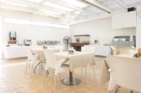 Un comedor con mesas blancas y sillas blancas. en Sweet Memories STANDARD Apts, en Protaras