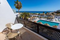a balcony with a table and chairs and a swimming pool at Sol Fuerteventura Jandia - All Suites in Morro del Jable