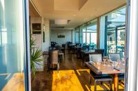 Un restaurante con mesas y sillas de madera y ventanas. en Le Poisson d'Avril, en Le Guilvinec