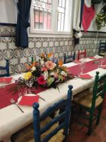 a long table with flowers on top of it at Habitaciones Castellon in Castellón de la Plana