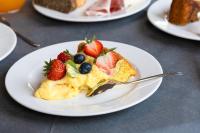 Un plato de comida con fruta en una mesa. en Hotel Levante Cesenatico, en Cesenatico