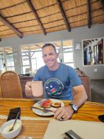 UsakosCarlo's Mountain Lodge的一位男士坐在桌边，面前摆着一盘食物