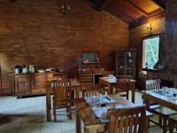 una sala da pranzo con tavoli e sedie in legno di Pousada dos Pássaros a Santo Antônio do Pinhal