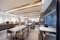 上海市にあるAtour X Hotel The Bund East Nanjing Roadのテーブルと椅子とキッチンのあるレストラン