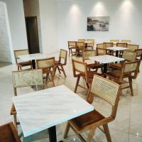 un grupo de mesas y sillas en una habitación en Bay Win La,mer Butik, en Kota Kinabalu