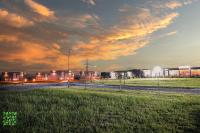 einen Blick auf ein Feld mit Gebäuden im Hintergrund in der Unterkunft Le Jardin Glamping in Oraviţa