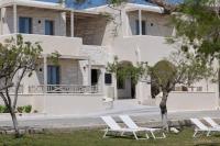 una fila de sillas blancas delante de una casa en Salt Suites Paros, en Naousa