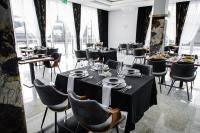 Un comedor con mesas y sillas y ventanas. en Wisteria Hotel, en Laskowiec