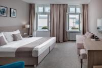 a bedroom with a bed and a couch and windows at Hotel Florenc in Prague