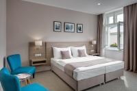 a hotel room with a bed and a blue chair at Hotel Florenc in Prague