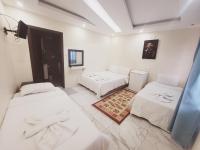 Tres camas en una habitación con paredes blancas. en shah sultan Ozturk Hotel, en Pamukkale