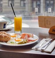 a plate of breakfast food and a glass of orange juice at Hotel Florenc in Prague