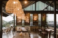 un restaurant avec des tables en bois et un grand lustre dans l'établissement Panora Doichang, à Ban San Pu Loei