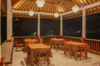ein Restaurant mit Tischen und Stühlen auf einer Terrasse in der Unterkunft Villa Lumbung Sidemen in Sidemen