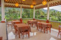 ein Restaurant mit Tischen und Stühlen auf einem Balkon in der Unterkunft Villa Lumbung Sidemen in Sidemen