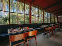 ein Restaurant mit Tischen und Stühlen und großen Fenstern in der Unterkunft Oaga Art Resort Maldives - Greatest All Inclusive Plan in Nord-Malé-Atoll