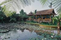 een huis met een vijver en een tuinhuisje bij The Fire Flies Garden Villa in Penginyahan