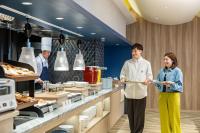 een man en een vrouw staan in een keuken bij KAMENOI HOTEL Kujukuri in Asahi