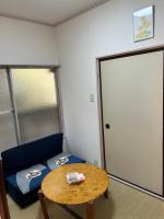 Zimmer mit blauem Sofa, Tisch und Tür in der Unterkunft ハイツドリーム梦想小屋 in Tokio