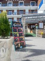 Un cartel delante de un edificio con una pantalla. en Hôtel L'Oustalet, en Font-Romeu-Odeillo-Via