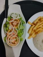 un plato de comida con ensalada y papas fritas en Suites Vitasha - Ubatumirim, en Ubatuba