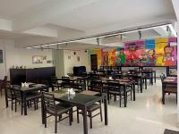 Un comedor con mesas y sillas y un mural. en Hotel Grand Continent - HiTec City, Laxmi Cyber City, Hyderabad, en Hyderabad