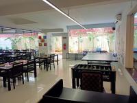 Un comedor con mesas y sillas y un escritorio. en Hotel Grand Continent - HiTec City, Laxmi Cyber City, Hyderabad, en Hyderabad