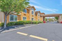 una casa amarilla con un árbol y una calle en Quality Inn near Six Flags Discovery Kingdom-Napa Valley, en Vallejo