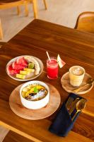 a table with two plates of food and a bowl of fruit at Uryah Hotel Lombok in Selong Belanak
