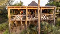 a wooden building with a restaurant on a beach at Sunset Lodge in Miramar