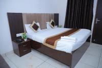 ein Schlafzimmer mit einem großen Bett mit einem hölzernen Kopfteil in der Unterkunft Hotel Green Apple BAREILLY in Bareilly
