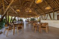 a dining room with wooden tables and chairs at Uryah Hotel Lombok in Selong Belanak