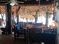 Un restaurante con mesas y sillas en una sala. en 1Vida Bar Restaurante, en Guayacanes