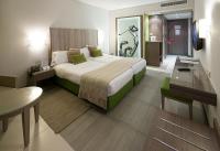 Una habitación de hotel con una cama grande y un escritorio. en Golf Royal Hotel, en Túnez