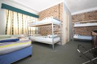a bedroom with two bunk beds and a brick wall at Acacia Snowy Motel in Jindabyne