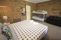 a room with a bed and a couch in a room at Acacia Snowy Motel in Jindabyne